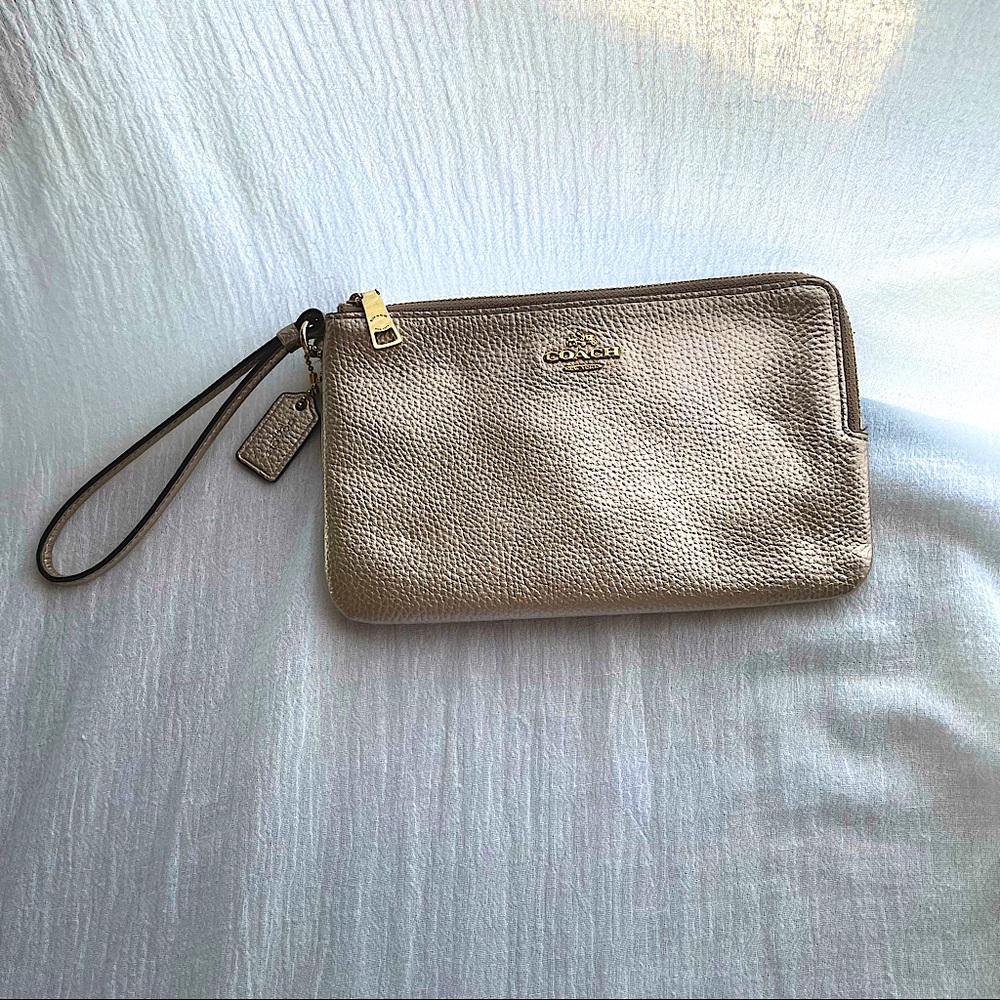 Coach wristlet bag rose gold blush leather with gold accents.